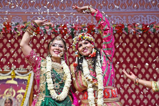 Temple Holi Traditions: Showering flower petals on devotees as they celebrate Phoolon Ki Holi in a spiritual atmosphere.