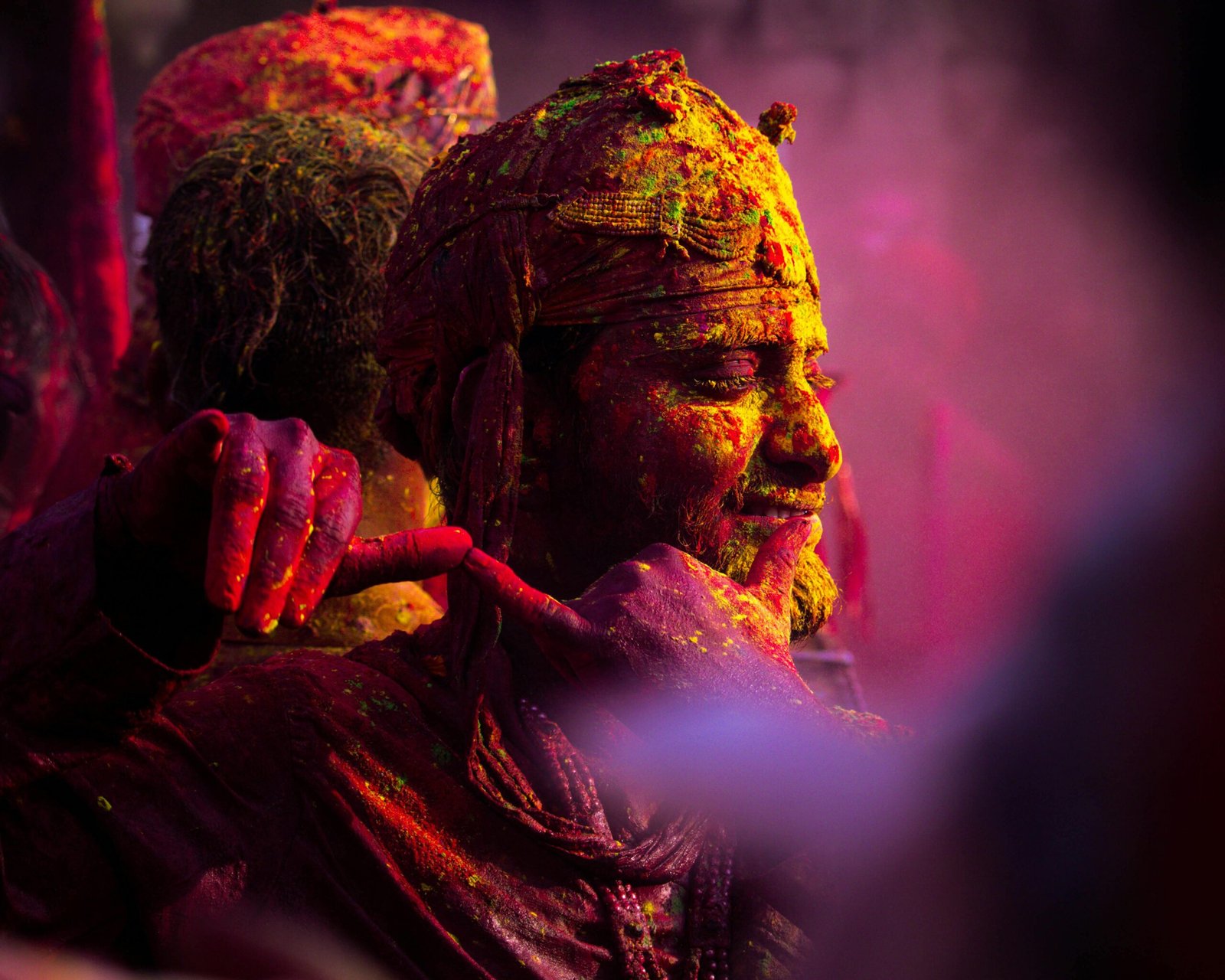 Colorful Holi celebration in Vrindavan with people covered in vibrant powder.