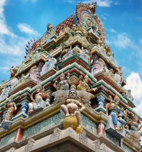 Vibrant gopuram of a Hindu temple in Salem, India, showcasing intricate designs under a blue sky.
